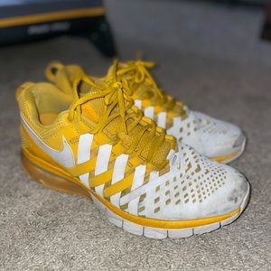 Gold/white Nike men’s tennis shoes